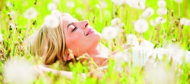 Close-up of a beautiful young woman among dandelions.