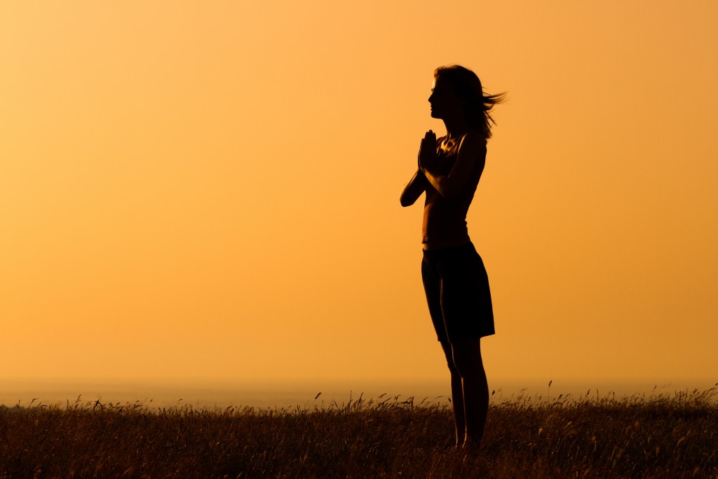Silhouette of a woman meditating.