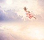 Girl in a pink dress flying through the sky