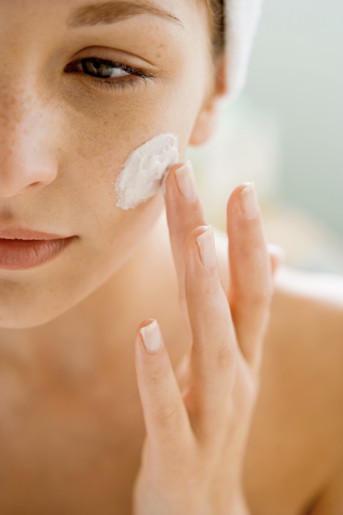 Woman using moisturizing cream on her face